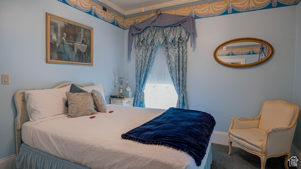 Carpeted bedroom with ornamental molding