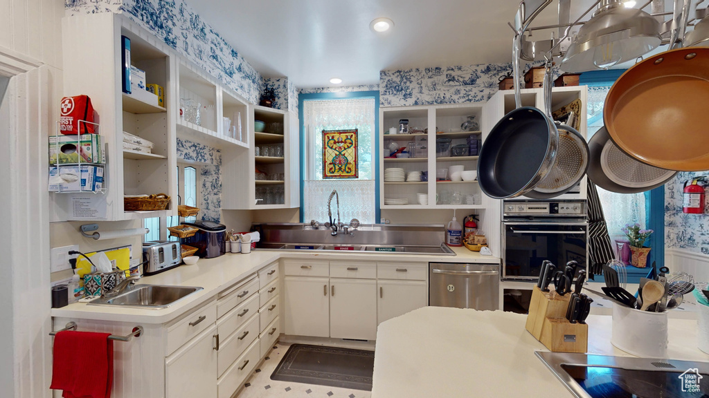 Kitchen with sink, oven, white cabinets, and dishwasher