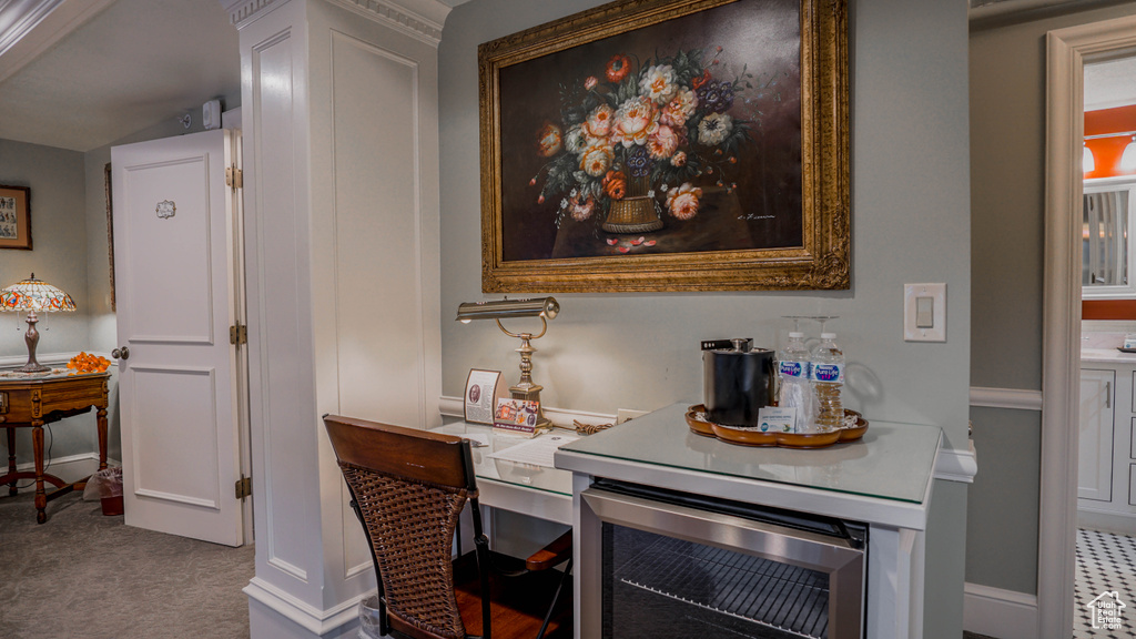 Interior space featuring beverage cooler, white cabinets, and light colored carpet