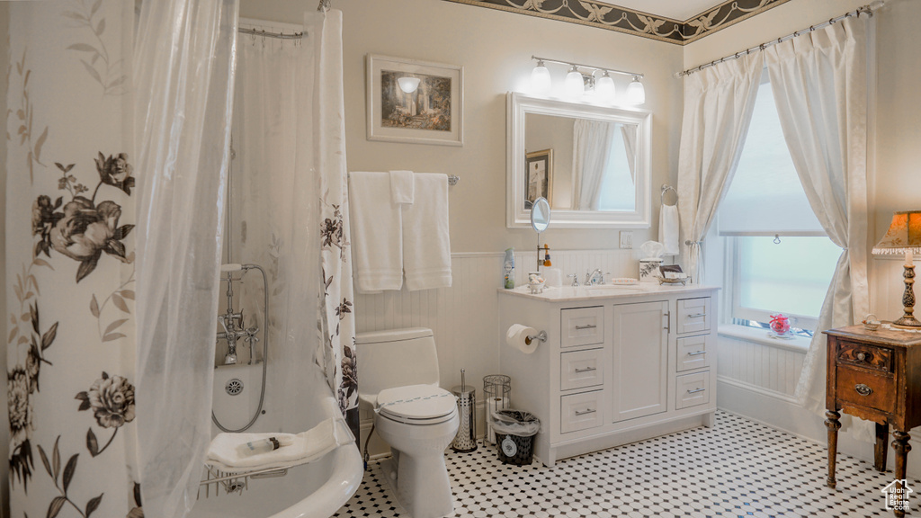 Bathroom featuring tile floors, large vanity, and toilet