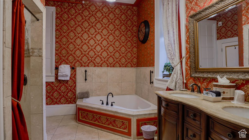 Bathroom with dual bowl vanity, tiled bath, and tile floors