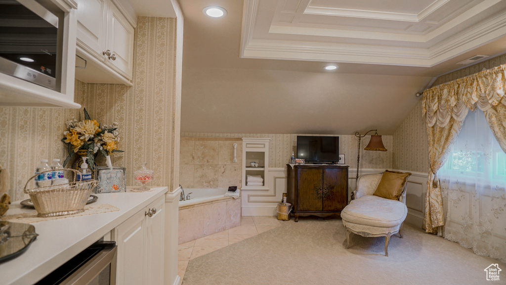 Bathroom with crown molding, tile flooring, tiled bath, and vanity