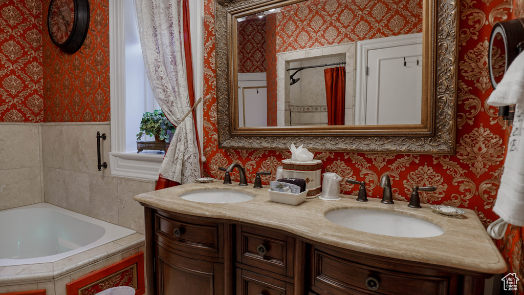 Bathroom featuring double vanity and a washtub