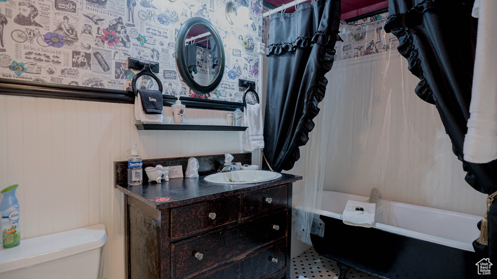 Bathroom with vanity with extensive cabinet space, toilet, and tile floors