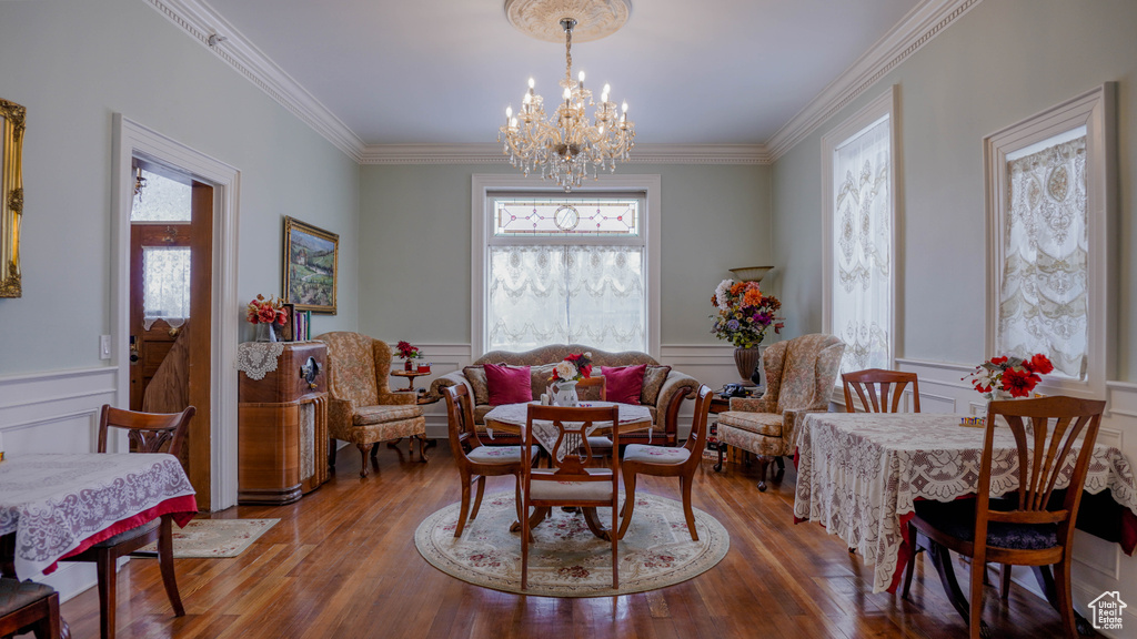 Dining room with a chandelier, ornamental molding, and hardwood / wood-style floors