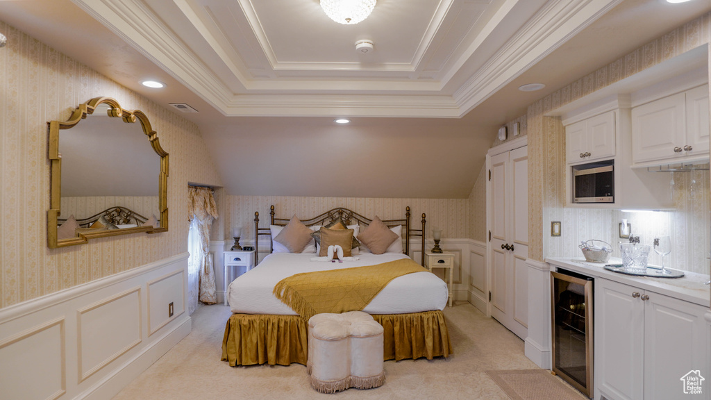 Carpeted bedroom featuring beverage cooler, a tray ceiling, crown molding, and bar