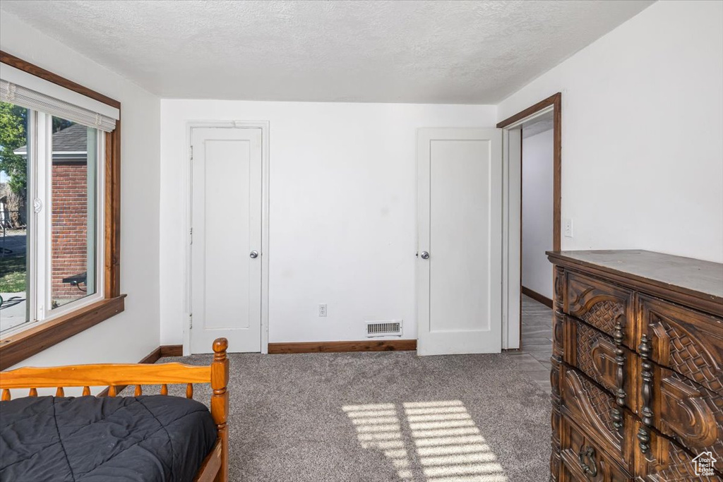 Bedroom featuring a textured ceiling and carpet