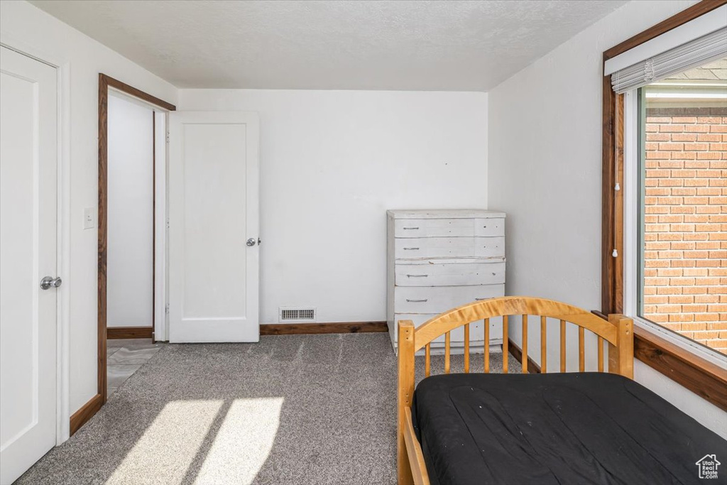 Bedroom with carpet and a textured ceiling