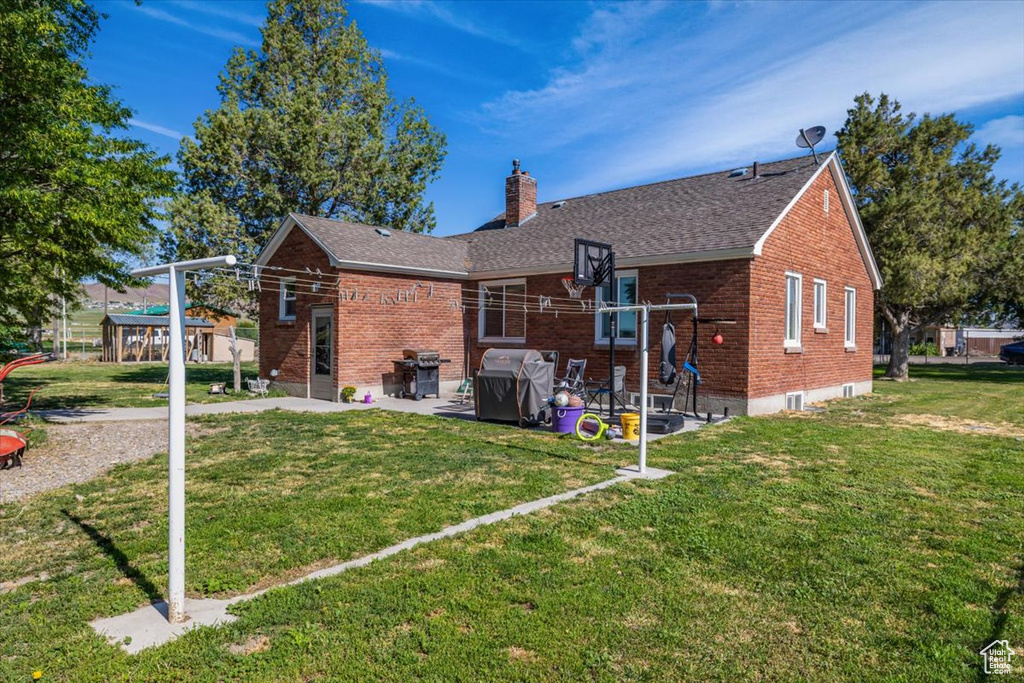 Rear view of house with a yard and a patio area