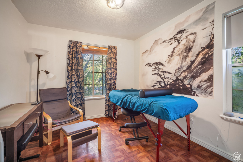 Bedroom featuring parquet floors and a textured ceiling