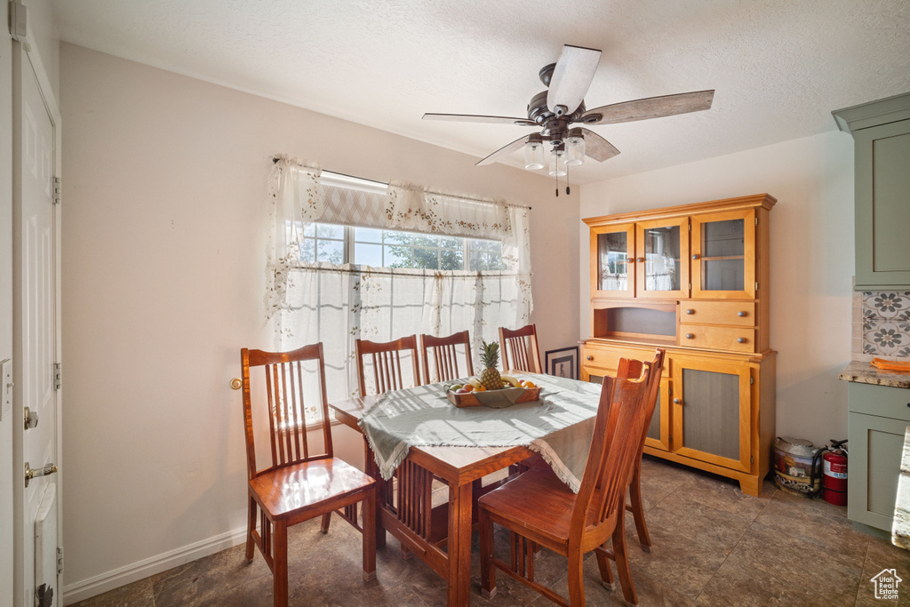 Tiled dining area featuring ceiling fan