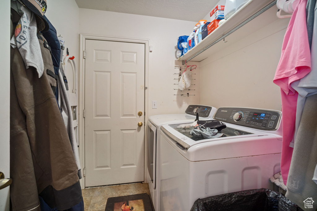 Clothes washing area featuring light tile flooring and washer and clothes dryer