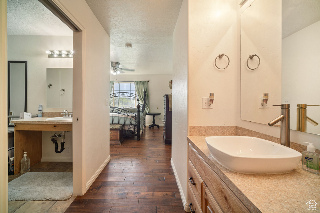 Bathroom featuring ceiling fan, vanity, a textured ceiling, and hardwood / wood-style floors