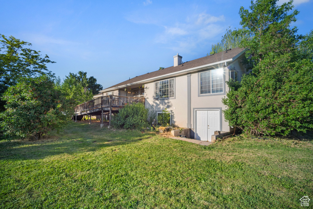 Back of property featuring a deck and a yard