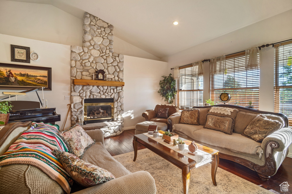 Living room featuring a wealth of natural light, hardwood / wood-style floors, a fireplace, and lofted ceiling