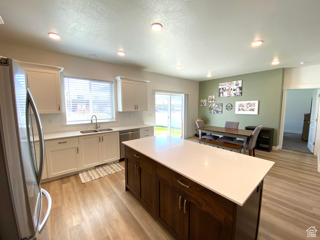 Kitchen featuring plenty of natural light, stainless steel appliances, light hardwood / wood-style flooring, and sink