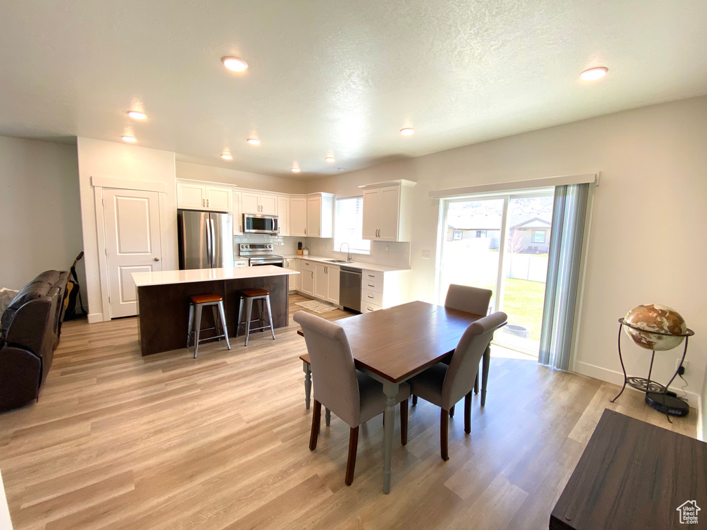 Dining space with sink and light hardwood / wood-style flooring