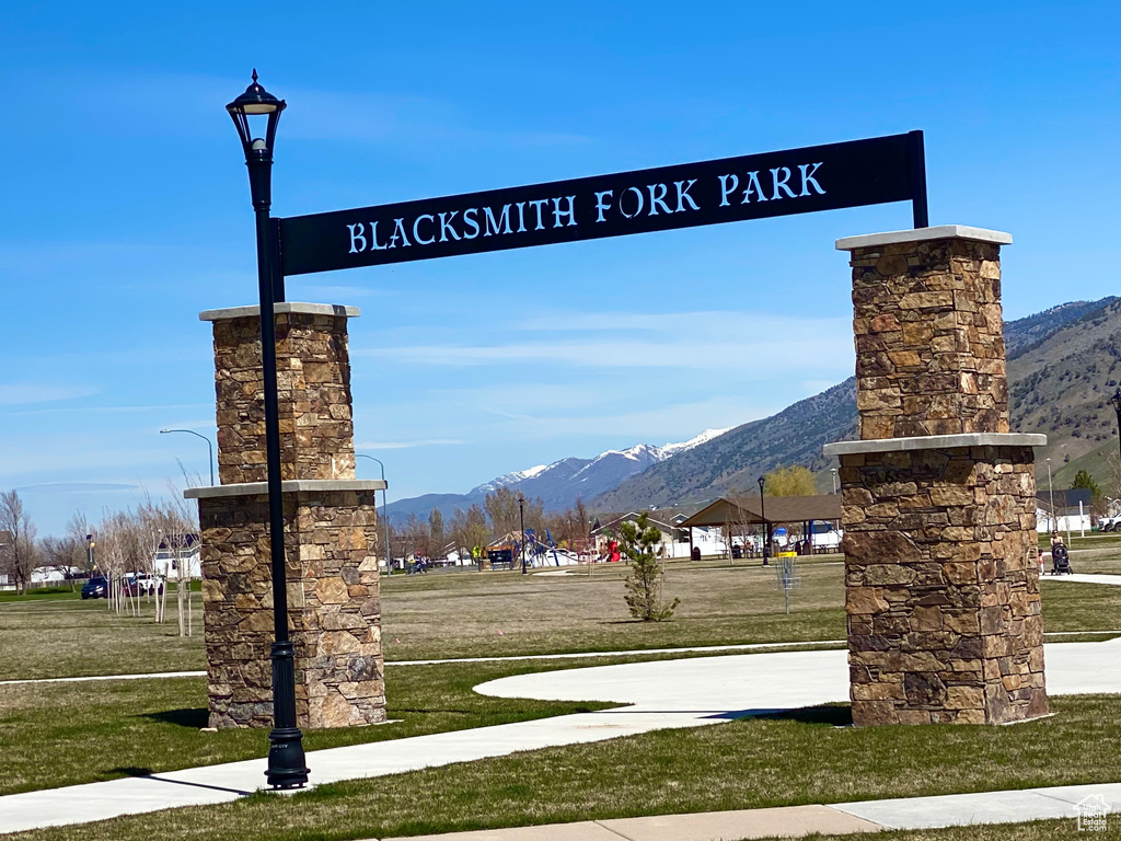 Community sign featuring a lawn and a mountain view