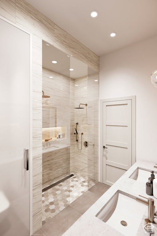 Bathroom featuring dual sinks and a shower with door