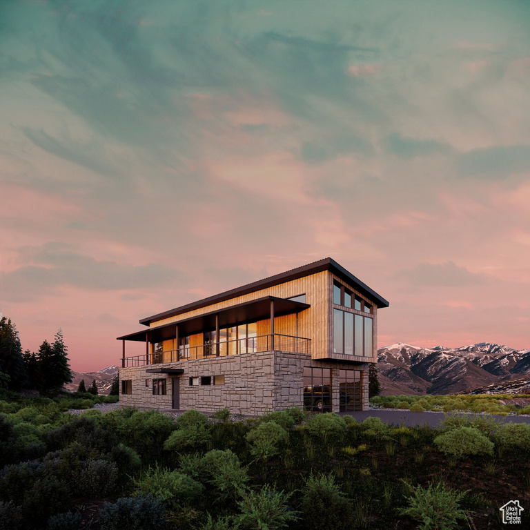 Back house at dusk with a mountain view and a balcony