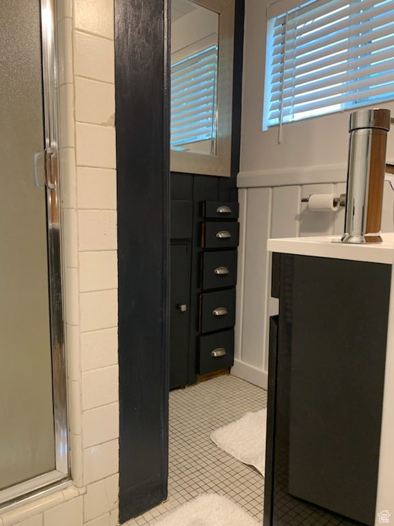 Bathroom with a shower with door, tile flooring, and vanity