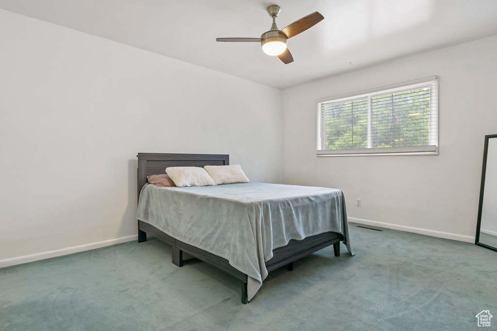 Carpeted bedroom featuring ceiling fan