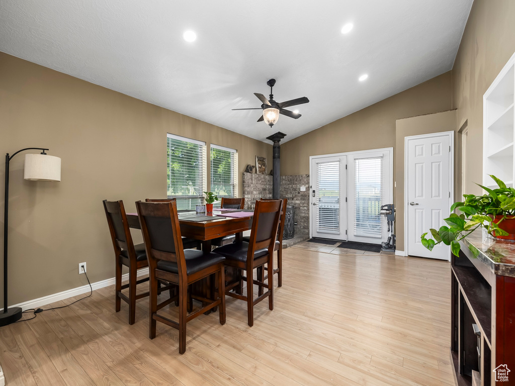 Dining room featuring a healthy amount of sunlight, lofted ceiling, light wood-type flooring, and ceiling fan