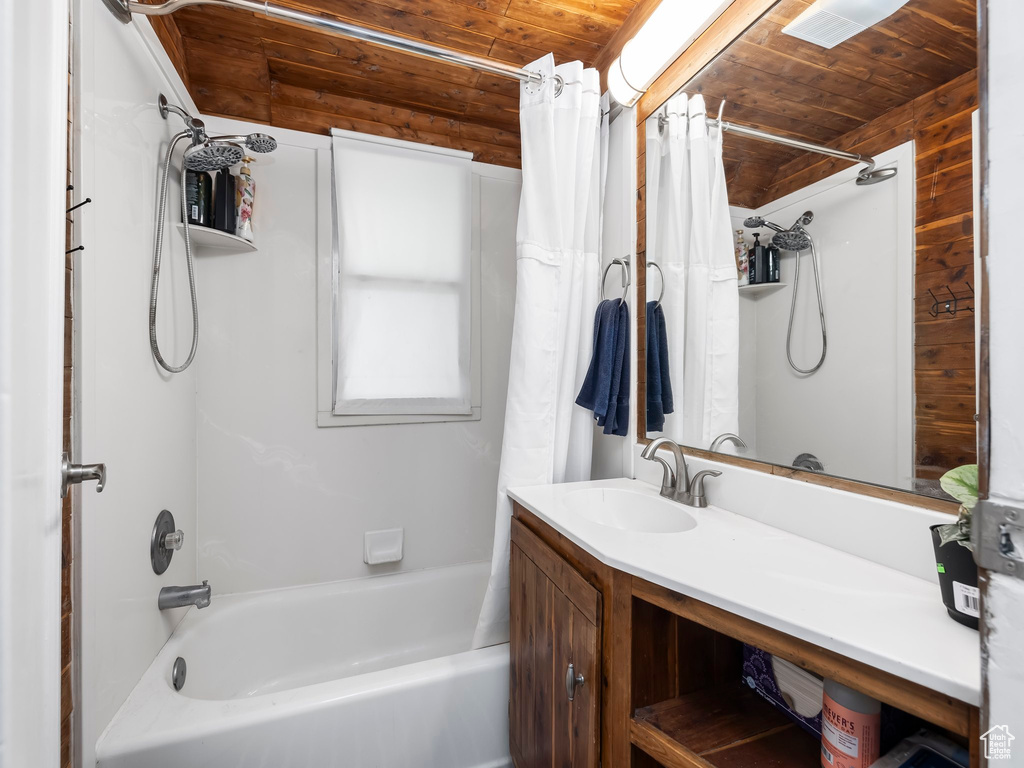 Bathroom featuring shower / bath combo with shower curtain, oversized vanity, and wood ceiling