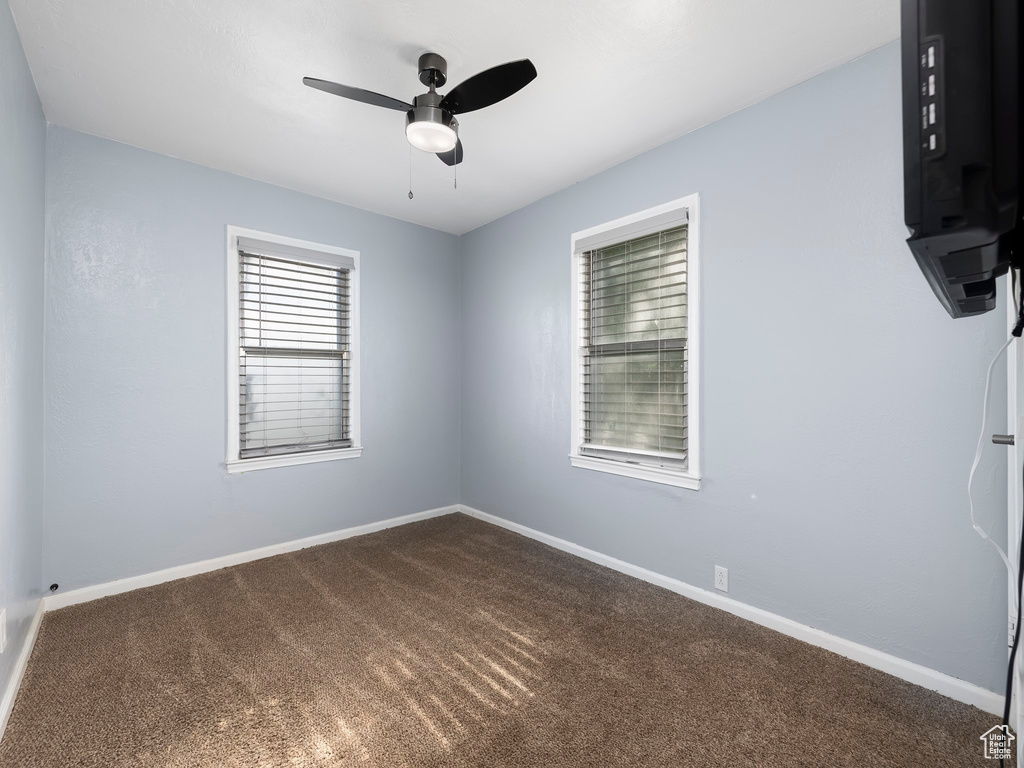 Carpeted empty room featuring ceiling fan