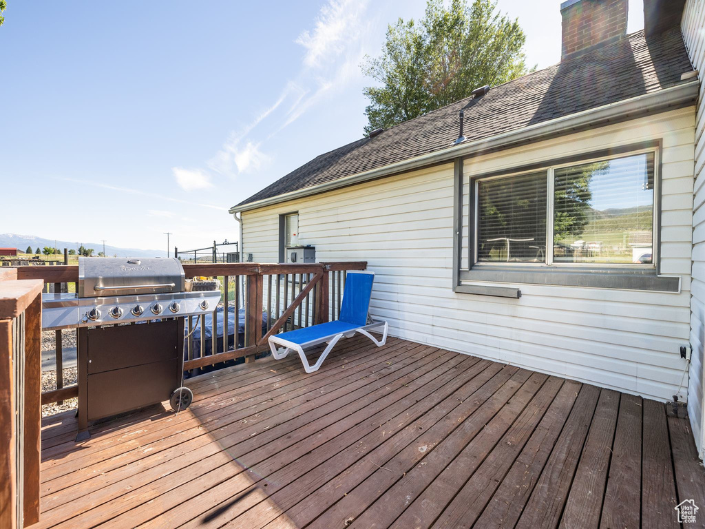 Wooden deck featuring a grill