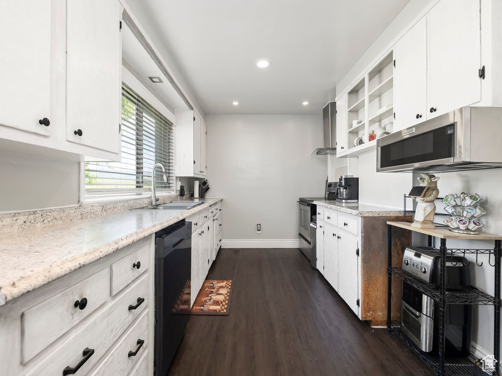 Kitchen with dark hardwood / wood-style floors, sink, white cabinetry, and appliances with stainless steel finishes