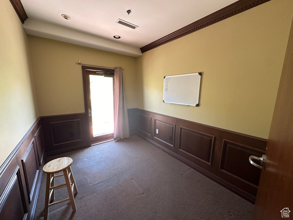 Carpeted empty room featuring crown molding