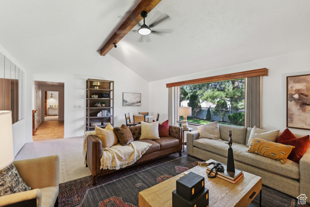 Living room with vaulted ceiling with beams, ceiling fan, and light hardwood / wood-style flooring