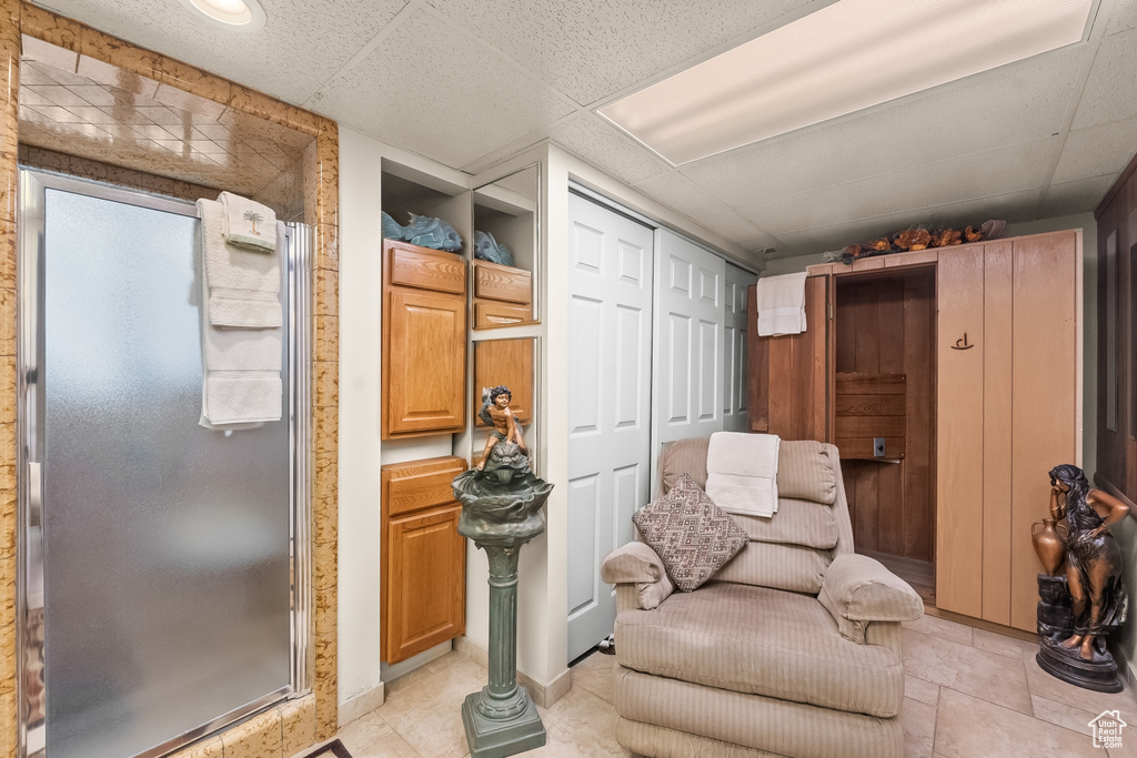 Living area with a drop ceiling and light tile patterned floors