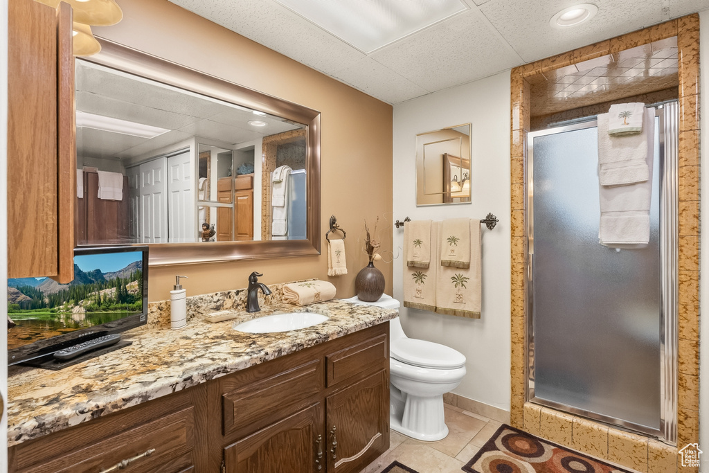 Bathroom with tile patterned flooring, vanity, toilet, and a shower with shower door