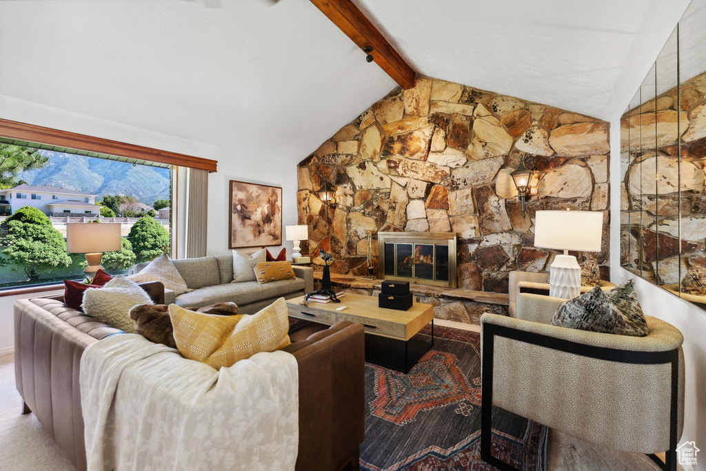 Living room with vaulted ceiling with beams and a stone fireplace