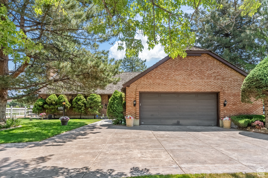 View of front of home with a garage and a front lawn