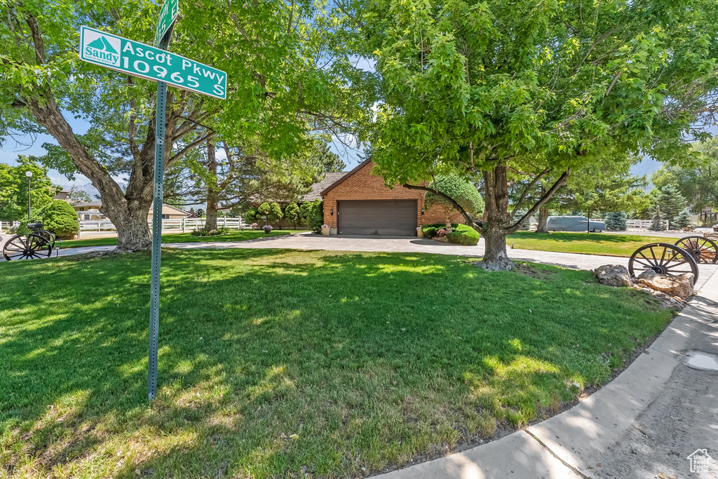 View of front facade featuring a garage and a front yard