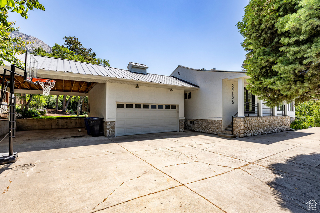 View of front of house with a garage and a carport