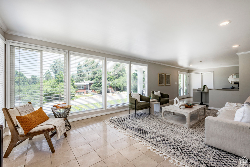 Tiled living room with crown molding and plenty of natural light