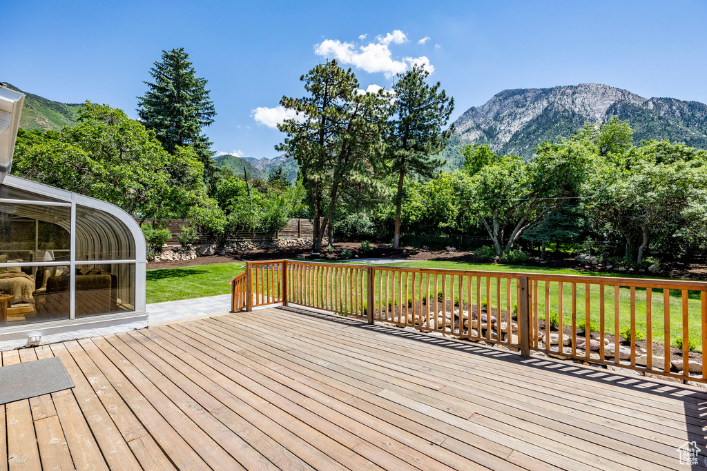 Deck with a yard and a mountain view