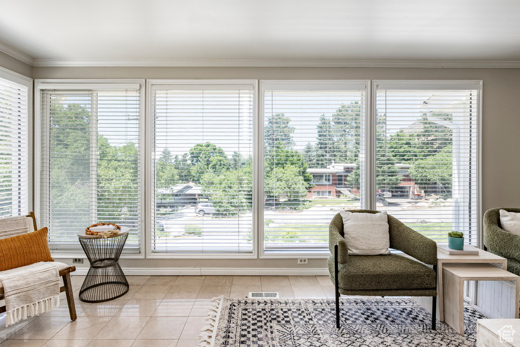 Living area with a healthy amount of sunlight and crown molding