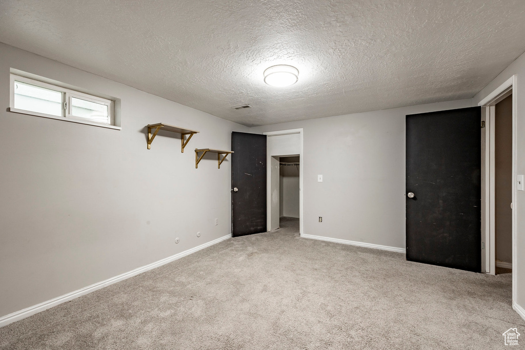 Carpeted spare room featuring a textured ceiling