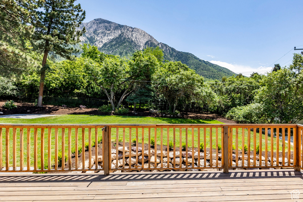 Wooden deck featuring a yard and a mountain view