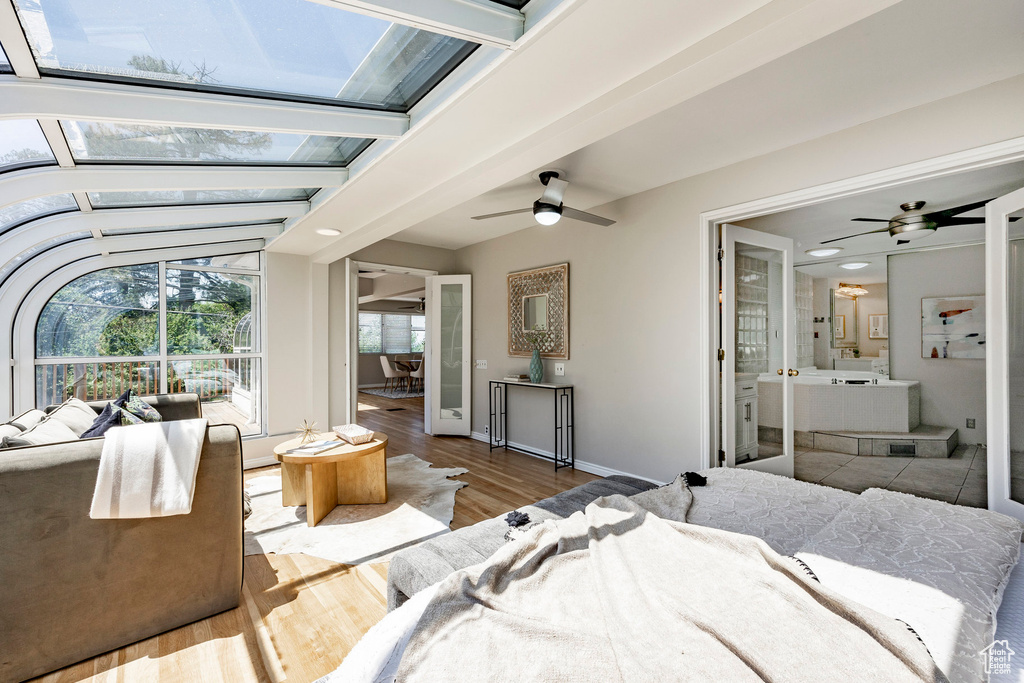 Bedroom with connected bathroom, lofted ceiling with beams, ceiling fan, and tile floors