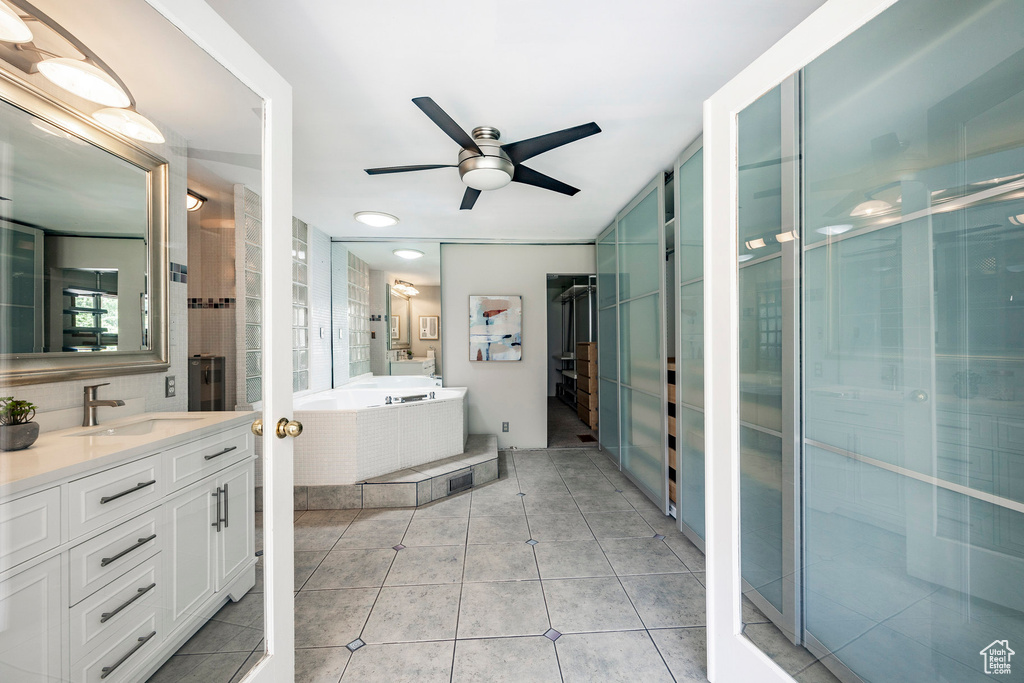 Bathroom featuring tile floors, ceiling fan, separate shower and tub, and vanity