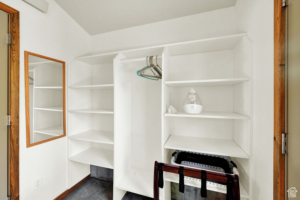 Walk in closet with dark hardwood / wood-style floors