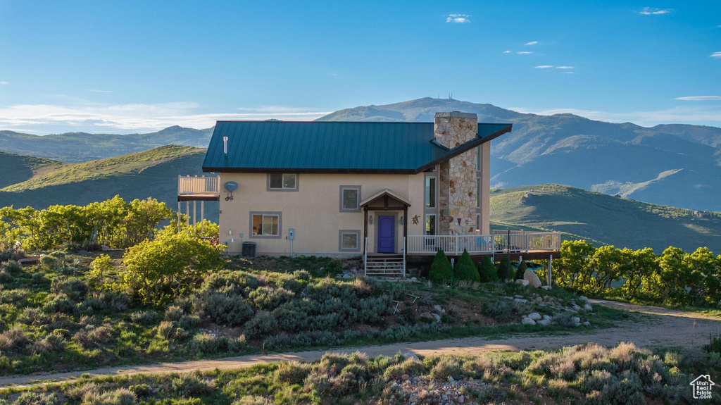 View of property with central AC unit and a mountain view