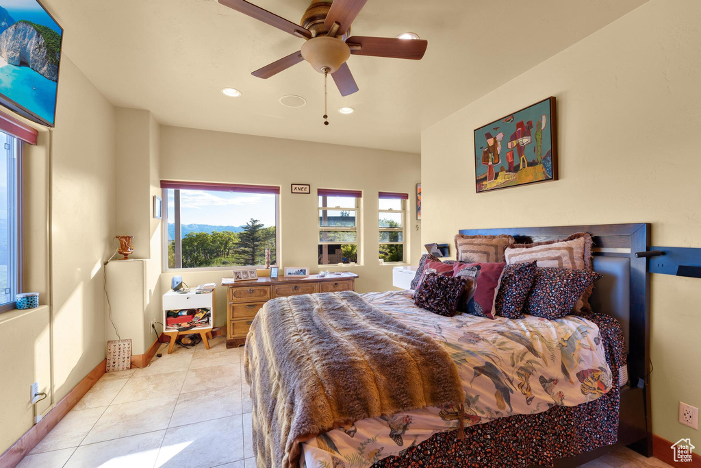 Tiled bedroom featuring ceiling fan