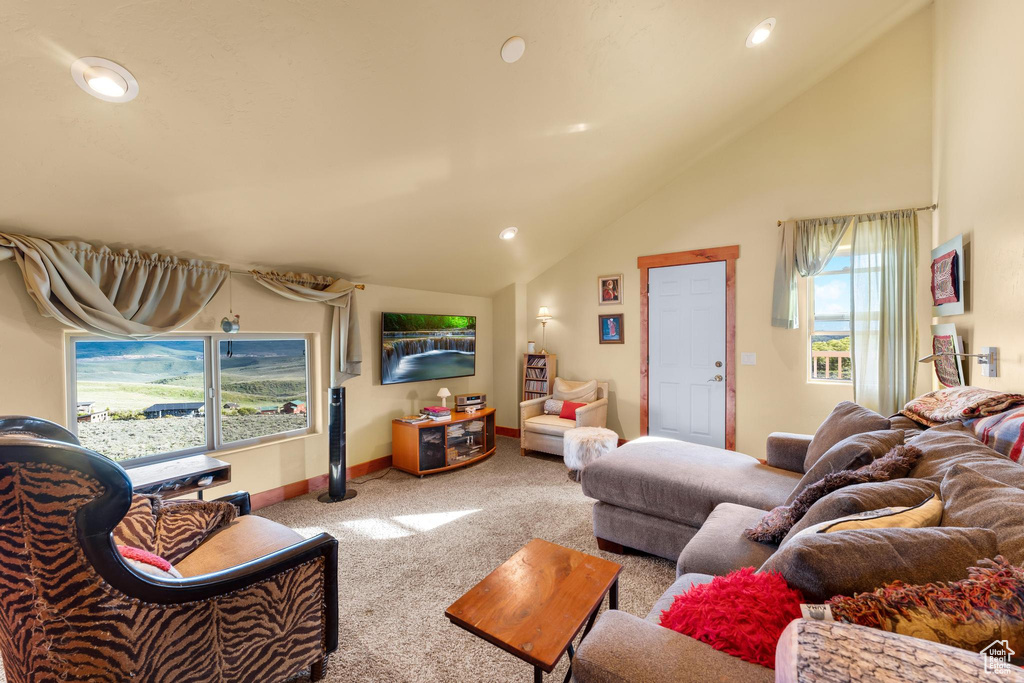 Living room with carpet flooring and high vaulted ceiling